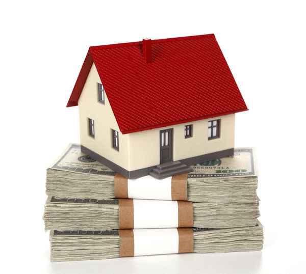Model home sitting on a stack of cash