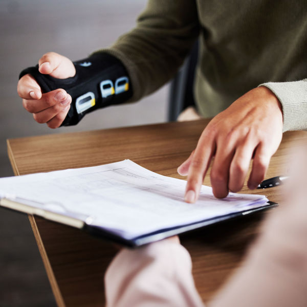 Person wearing and arm brace reviewing paperwork