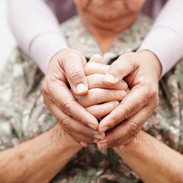Caregiver holding the hands of an elderly woman