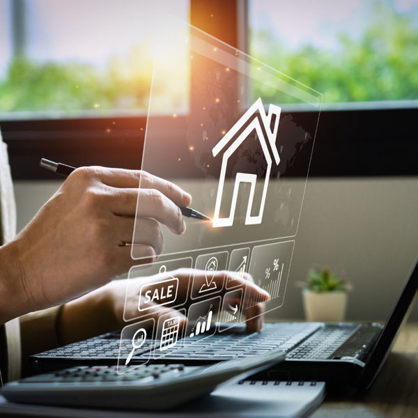 Professional working with a virtual display image of a home and real estate icons