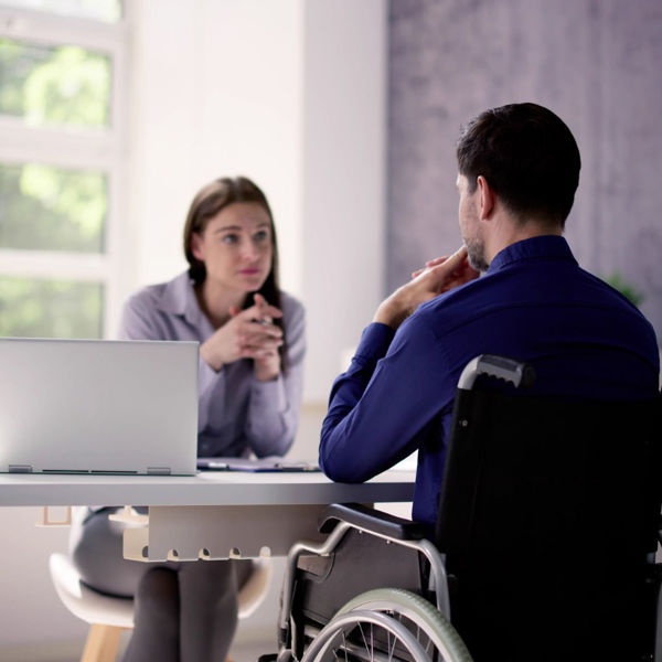 Female attorney speaking to man in wheelchair