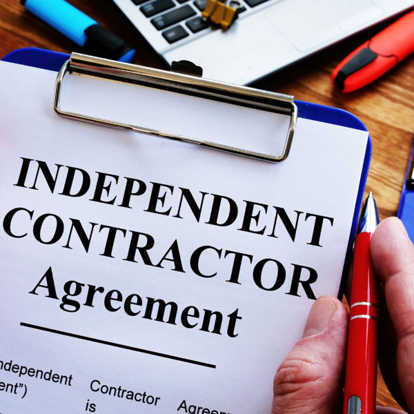 Close up of a man signing independent contractor agreement