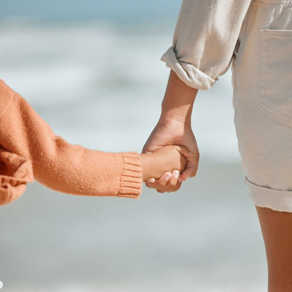 close up of little girl holding woman's hand