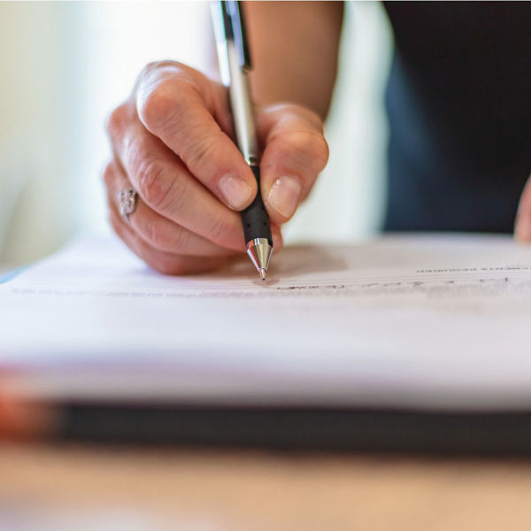 Close up of a female real estate agent signing contract