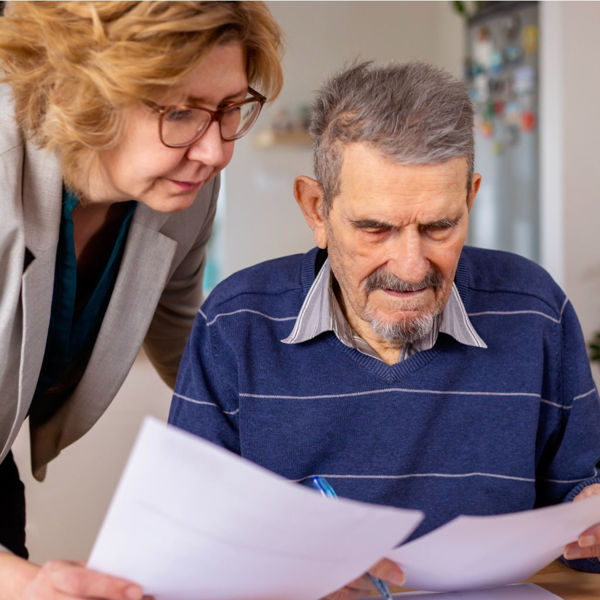 Elderly gentleman at table reviewing documents with attorney